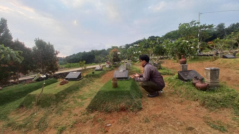 Seorang warga sedang ziarah kubur di Blok A permakaman Covid-19 TPU Jatisari Mijen, Kota Semarang. (Inibaru.id/ Fitroh Nurikhsan)