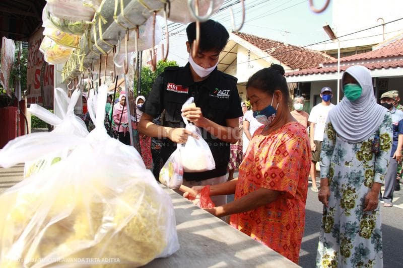 Sukarelawan ACT akan membantu dalam proses pembagian sedekah pangan.<br>