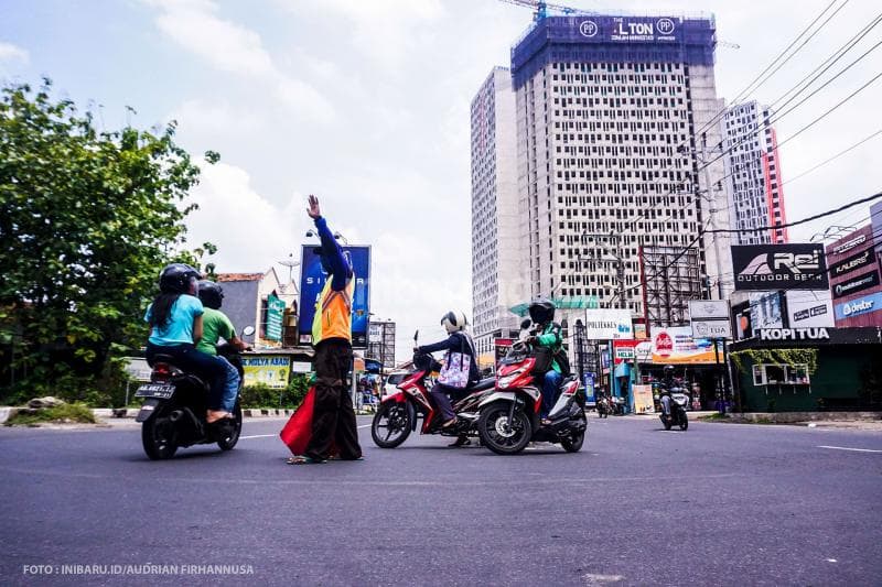 Pak Ogah di persimpangan jalan Prof Soedharto, Tembalang punya andil besar dalam menjaga keteraturan jalan dan mengurangi resiko kecelakaan.<br>