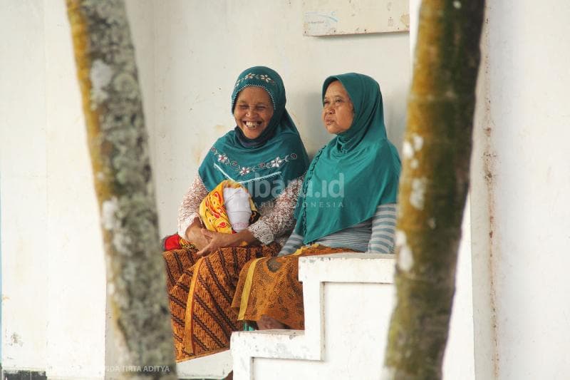 Dua nenek pengungsi bersenda gurau pada suatu sore. Mereka tetap bahagia meski dalam kondisi sulit.<br>
