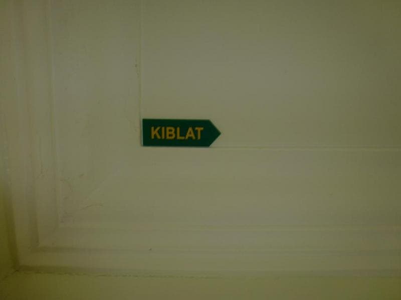 Tanda kiblat bisa dipasang di dinding, langit-langit, atau lantai. (Booking.com)