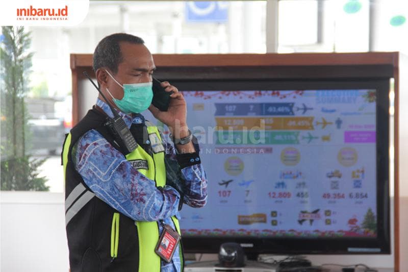 Petugas memantau pergerakan penumpang di Posko Terpadu Nataru, Bandara Internasional Jenderal Ahmad Yani Semarang, Jawa Tengah, Jumat (18/12/2020). Suasana bandara ini tampak lebih ramai menjelang periode libur Nataru. (Inibaru.id/ Triawanda Tirta Aditya)