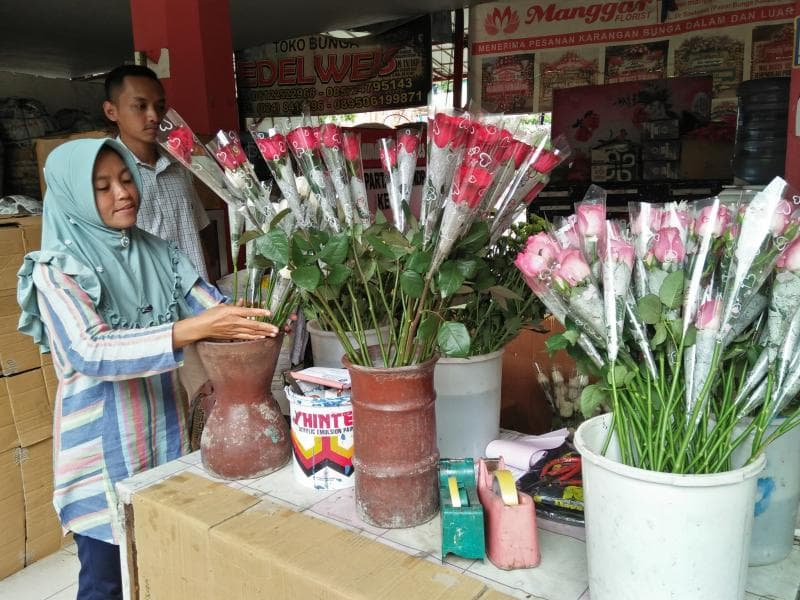 Seorang penjual bunga sedang menata bunga. (Inibaru.id/ Issahani)