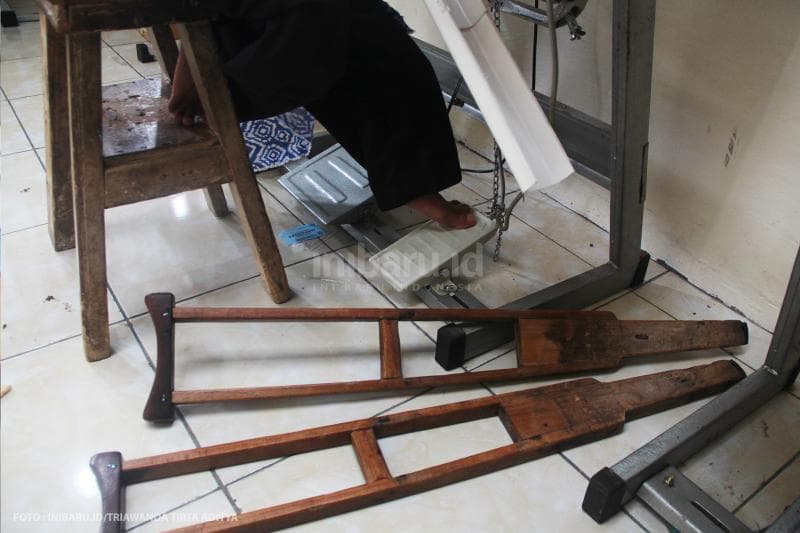 Saat menjahit, Ngatimin masih harus menggunakan kakinya meski mengalami cacat sejak kecil.<br>
