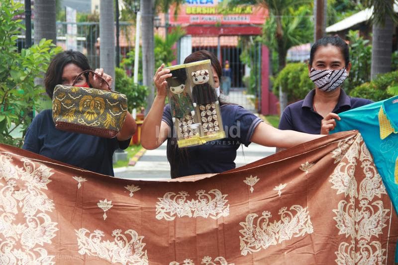 Tiga warga binaan di Lapas Wanita Semarang menunjukkan hasil karya mereka.<br>