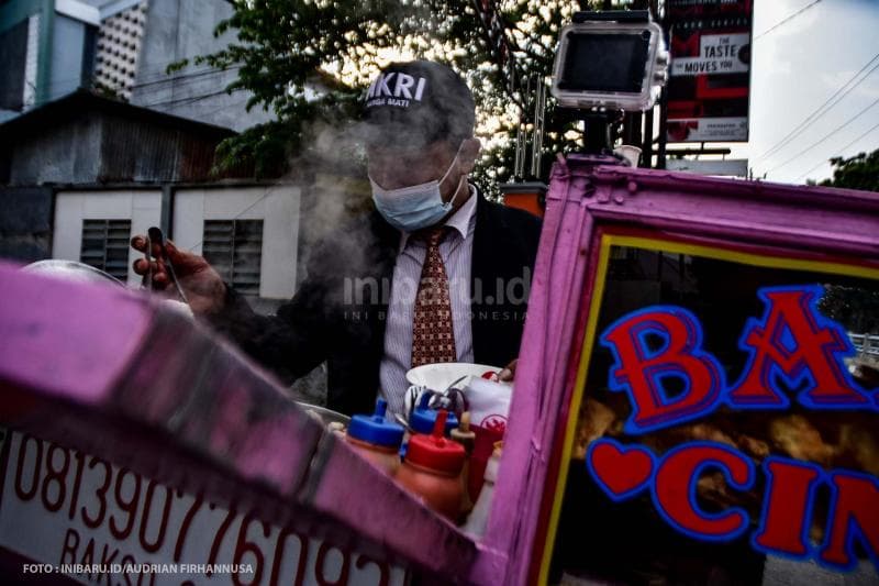 Menyajikan bakso untuk pelanggan.