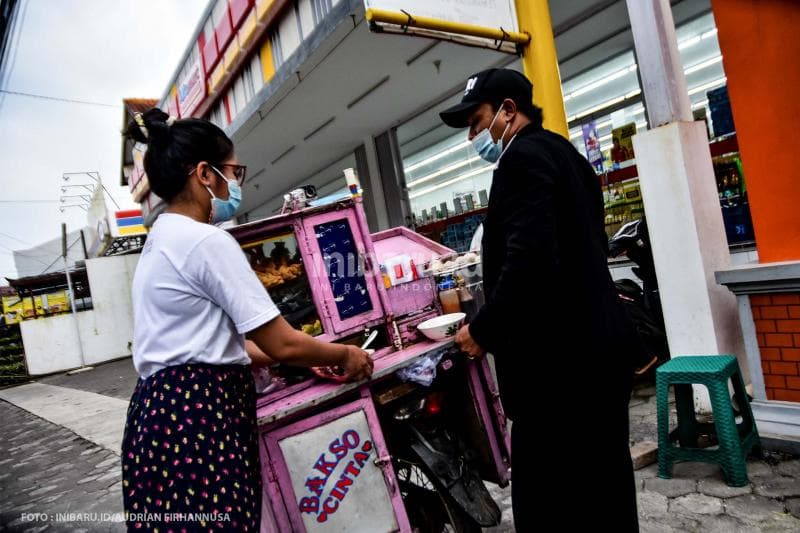 Suparjo melayani pelanggan di depan sebuah minimarket yang berlokasi di dekat kampus Undip.