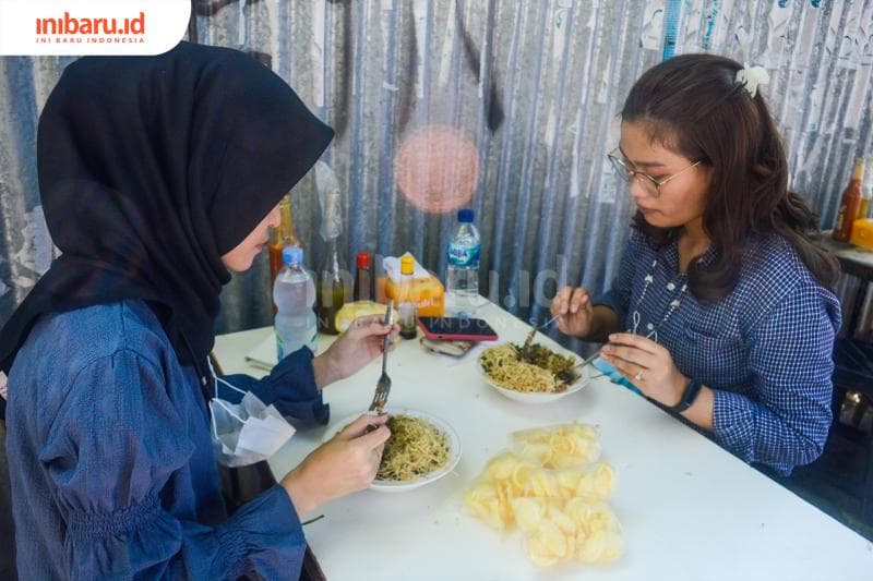 Rey (kanan) dan satu temannya yang datang untuk menikmati semanguk bubur ayam Mang Dede. (Inibaru.id/ Kharisma Ghana Tawakal)