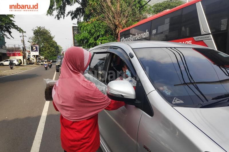 Ibu Lestari menawarkan korannya dari mobil ke mobil.(Inibaru.id/Bayu N)