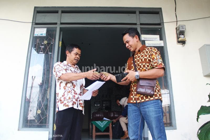 Warga membeli voucher SuryaNett dari perangkat desa Kadirejo.<br>