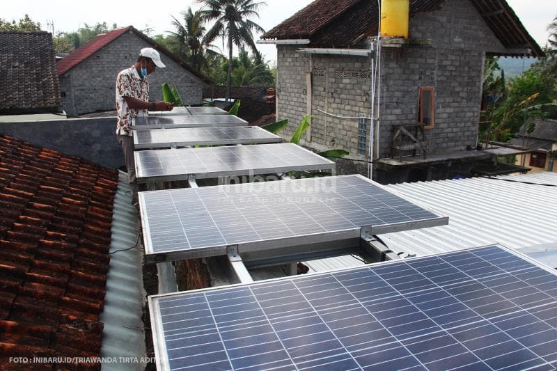 Kades Kadirejo Riyadi mengecek kabel tenaga surya.<br>