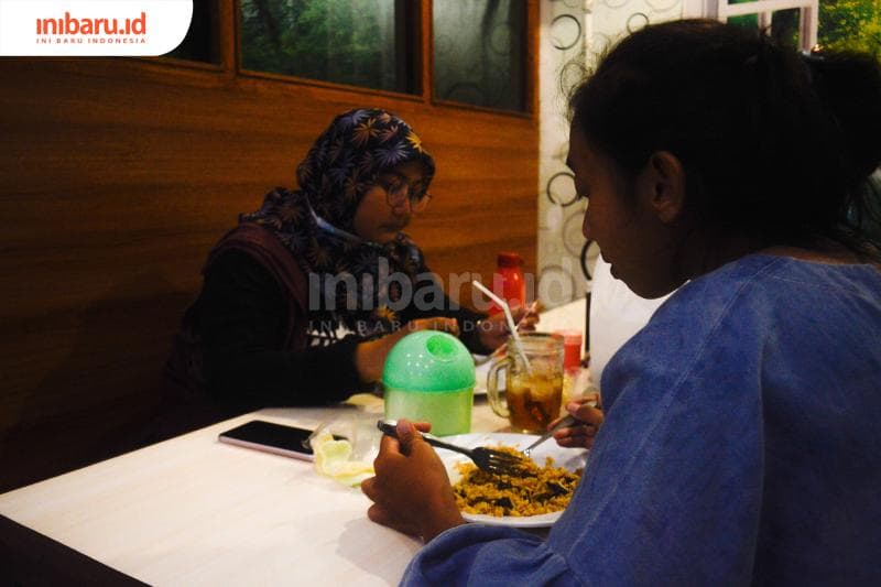Fitri (kiri) dan Novia (kanan) pelanggan Nasi Goreng Padang Bangjo yang sudah sering jajan disini sejak tahun 2012. (Inibaru.id/Kharisma Ghana Tawakal)