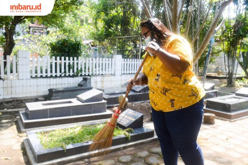Hartatik, salah seorang juru kunci di Makam Bergota Semarang yang sedang melakukan kewajibannya membersihkan area makam. (Inibaru.id/Kharisma Ghana Tawakal)
