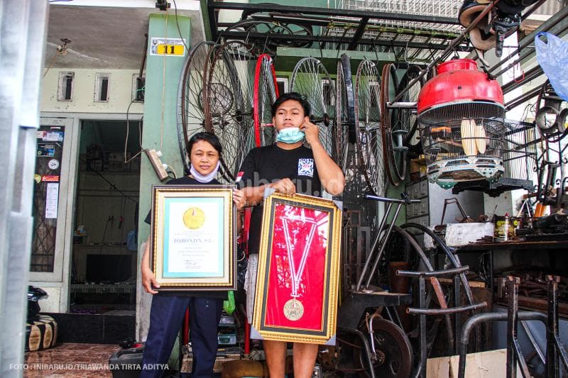 Istri dan anak Daronjin menunjukkan piagam penghargaan milik sang maestro.<br>