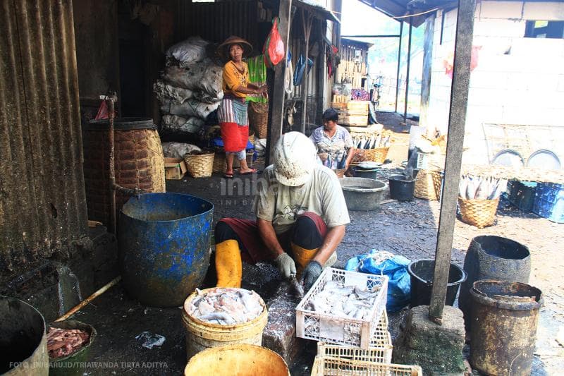 Suasana pekerja yang sibuk membersihkan ikan.<br>