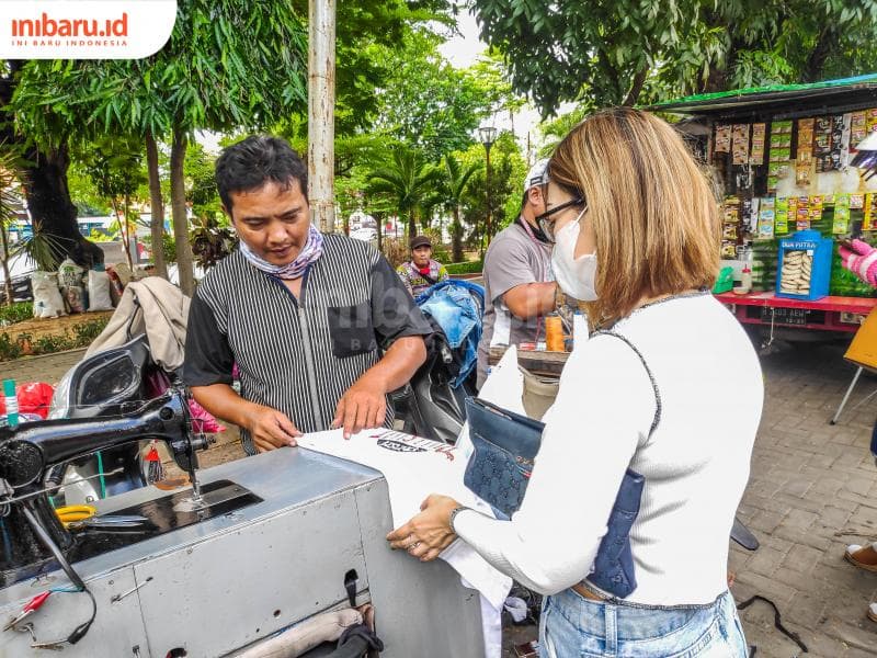 Anshor tengah mendiskusikan bentuk permak yang diinginkan pelanggannya. (Inibaru.id/ Bayu N)