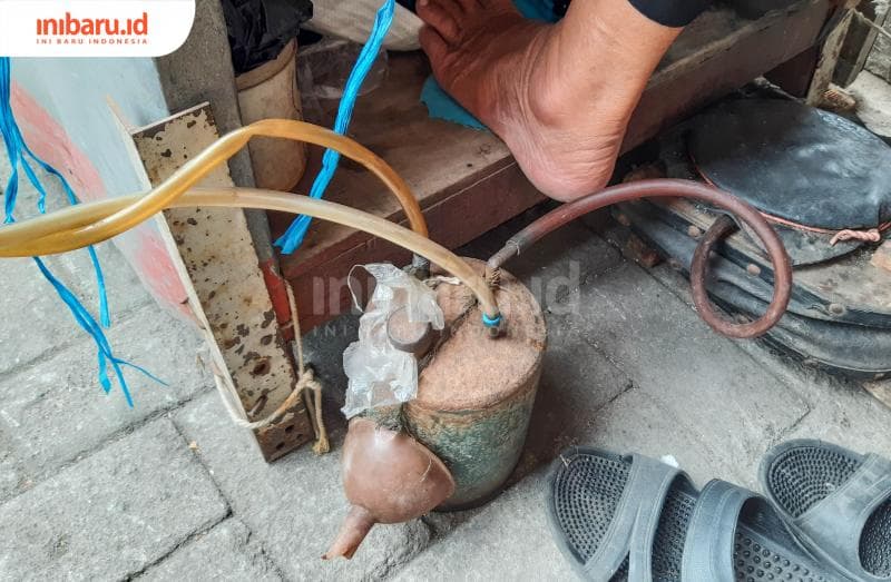 Selang dan pompa yang digunakan sebagai alat untuk menghantarkan bensin sebagai sumber daya utama api dalam mematri emas.&nbsp;(Inibaru.id/Kharisma Ghana Tawakal)