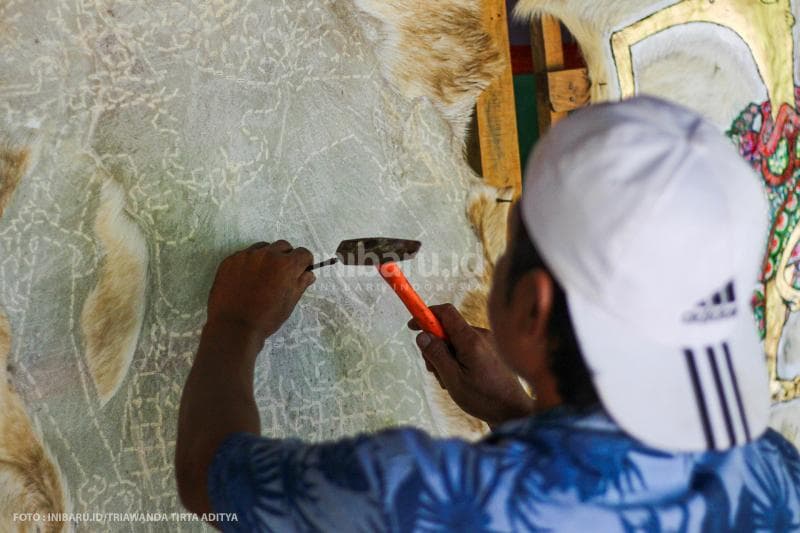 Langkah pertama, Kumoro harus memahat kulit kambing untuk membuat pola.