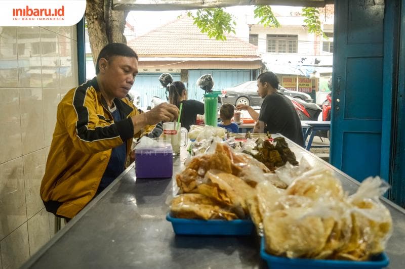 Agus, salah seorang pelanggan yang sedang mengaduk segelas STMJ. (Inibaru.id/Kharisma Ghana Tawakal)