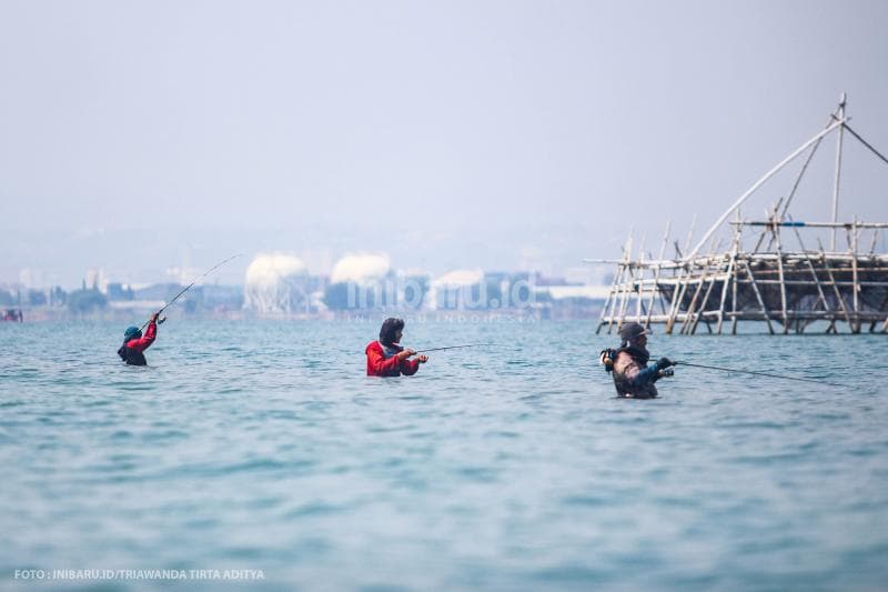 Tiga pemancing sedang asyik mencari ikan di tengah laut dekat dengan Dam Ijo Semarang.