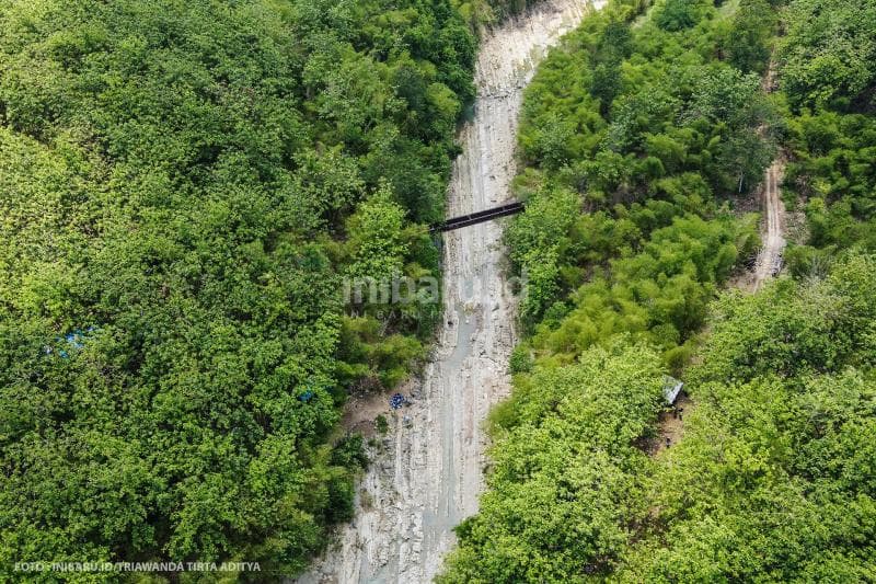 Sungai ini diapit hutan dan pohon.