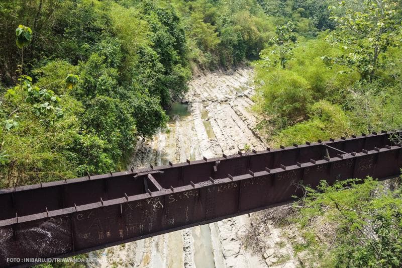 Ada jembatan kuno peninggalan Belanda di atas sungai.