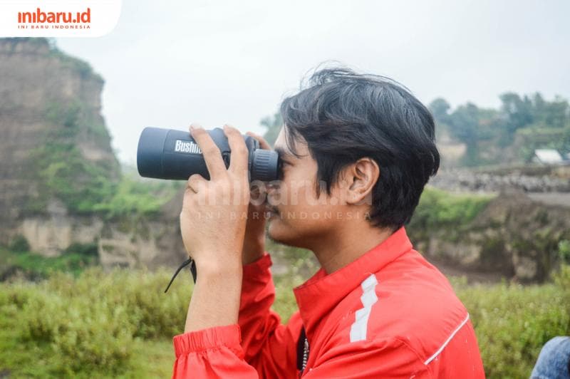 Salah seorang anggota LPFS yang meneropong burung yang diterbangkannya. (Inibaru.id/ Kharisma Ghana Tawakal)