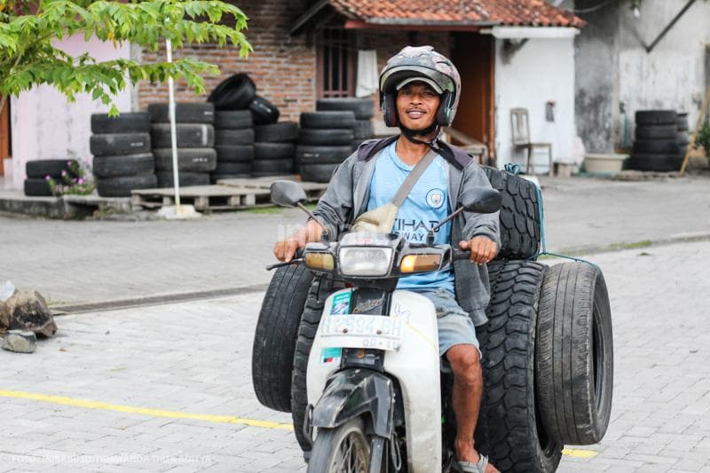 Salah seorang warga datang dengan mengangkut ban bekas di atas motornya.
