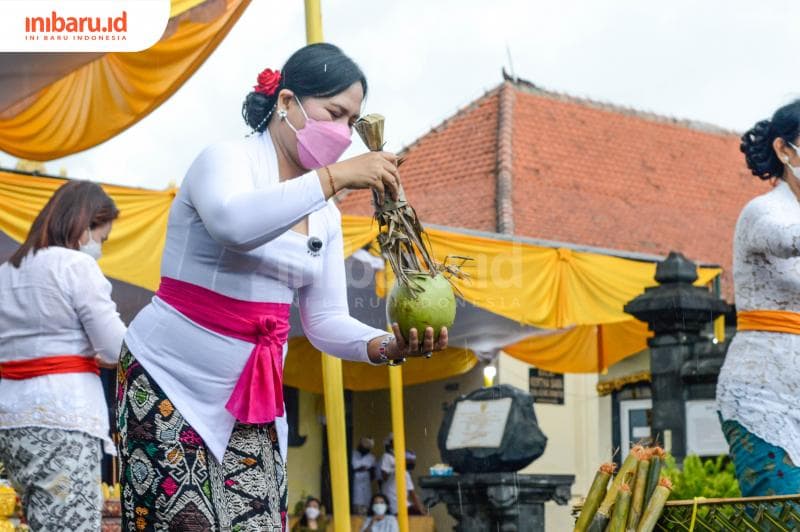 Memercikkan air pada kelapa, pada Perayaan Tawur Agung Kesanga. (Inibaru.id/Kharisma Ghana Tawakal)