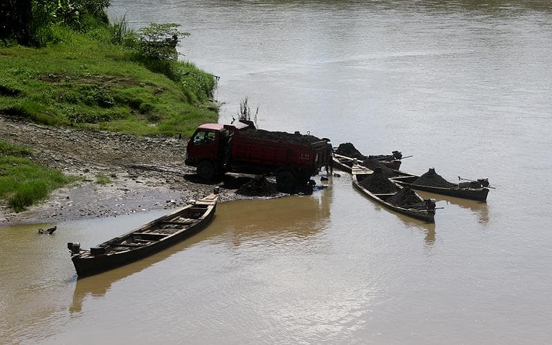 Para penambang pasir di Sungai Klawing memasukkan pasir ke dalam truk. (Law-justice.co/Robinsar Nainggolan)