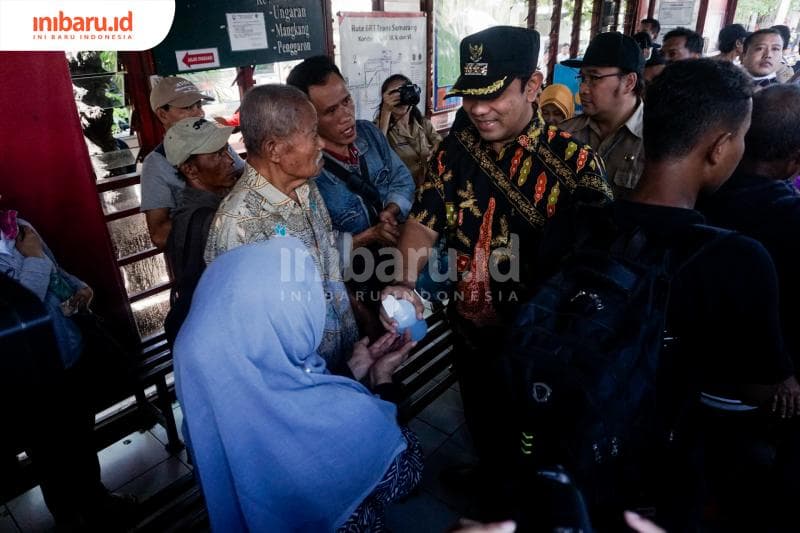 Hendi memberikan cairan hand sanitizer kepada penumpang BRT. (Inibaru.id/ Audrian F)<br>