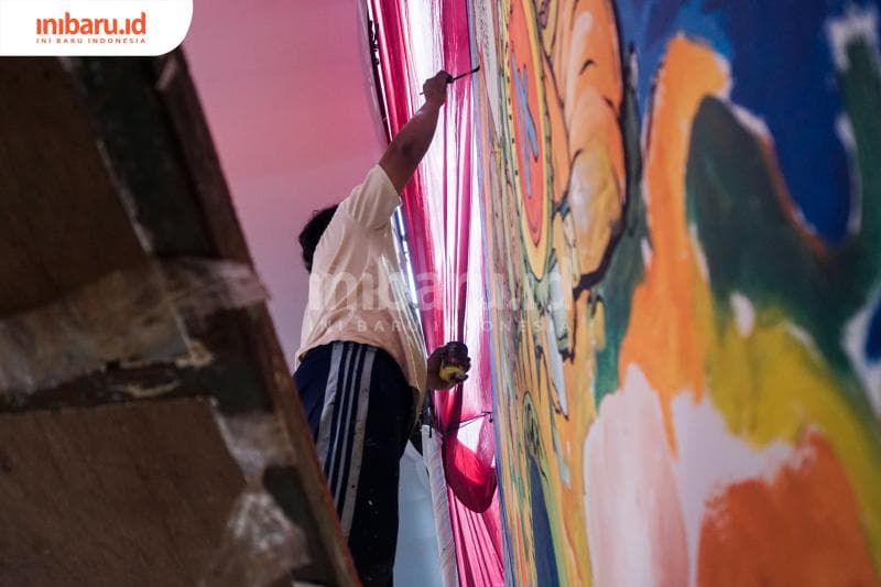 Salah satu penggambar mural pada lomba mural yang diselengarakan oleh Bank Indonesia Jawa Tengah, Sabtu (14/3). (Inibaru.id/ Audrian F)<br>