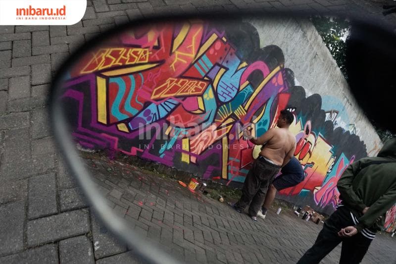 Para penggiat grafiti Kota Semarang saling menuangkan kreativitasnya. (Inibaru.id/ Audrian F)<br>