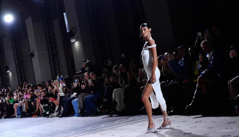 Meski disemprot, gaun yang dipakai Bella Hadid bisa membentuk kain sebagaimana pakaian pada umumnya. (Liputan6/AFP-Julien De Rosa)