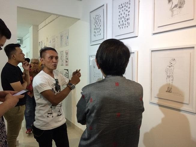Kokoh Noegroho sedang memberikan penjelasan kepada pengunjung. Mengobrol dengan pembuat lukisan membuat kita bisa menanyakan langsung hal-hal yang belum dimengerti. (Sigijateng/Titis)