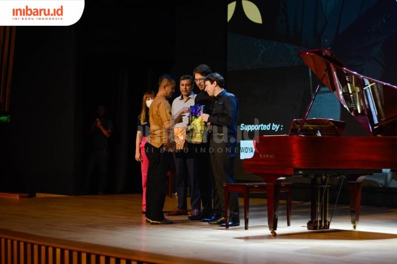 Pemberian buah tangan kepada pianis asal Belanda oleh&nbsp;Koordinator Budaya Yayasan Widya Mitra Seno Prakoso. (Inibaru.id/ Kharisma Ghana Tawakal)