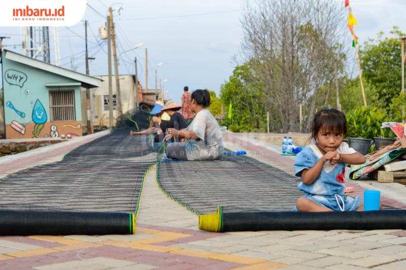 Gambaran kegiatan nelayan Tambakrejo dalam gotong-royong membuat jaring. (Inibaru.id/ Kharisma Ghana Tawakal)