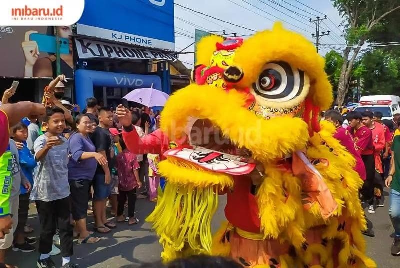 Para penonton bergantian nyawer ke mulut barongsai di tengah Kirab Budaya yang merupakan bagian dari Festival Imlek di Pati. (Inibaru.id/ Rizki Arganingsih)