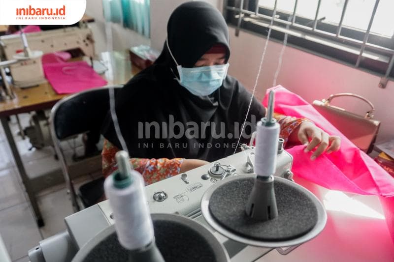 Salah seorang peserta pelatihan BLK yang sedang menjahit pakaian APD. (Inibaru.id/ Audrian F)<br>