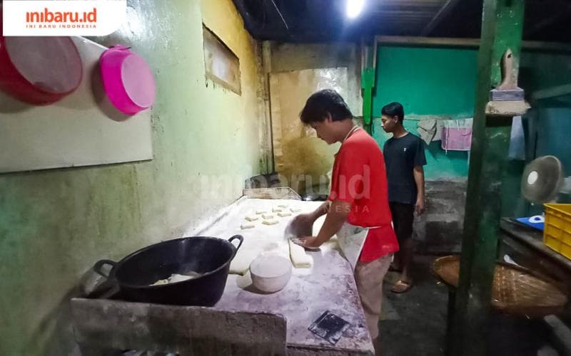 Seorang pegawai Bolang-baling Peterongan tengah memotong adonan sebelum digoreng. (Inibaru.id/Fitroh Nurikhsan)