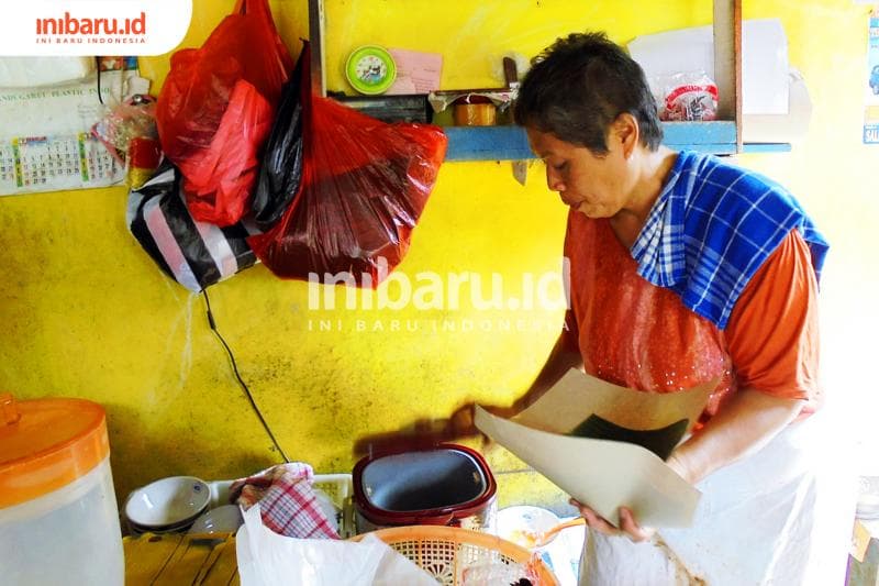 Mbak Mi tengah membungkus nasi pesanan pelanggan. (Inibaru.id/Isma Swastiningrum)