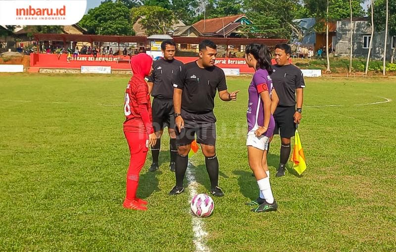 Seorang wasit tengah memberi arahan kepada kapten Persis Solo Women (merah) dan Pakuan City Bogor (ungu) sebelum bertanding. (Inibaru.id/ Fitroh Nurikhsan)