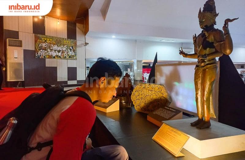 Seorang pengunjung sedang melihat salah satu benda bersejarah di pameran Museum Ranggawarsita Jawa Tengah. (Inibaru.id/ Fitroh Nurikhsan)