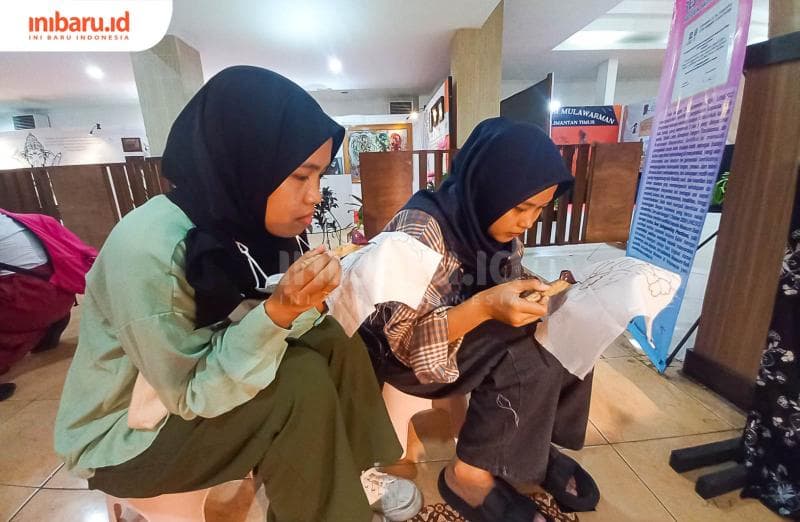 Dua orang pengunjung sedang belajar membatik di stand Museum Batik Kota Pekalongan. (Inibaru.id/ Fitroh Nurikhsan)