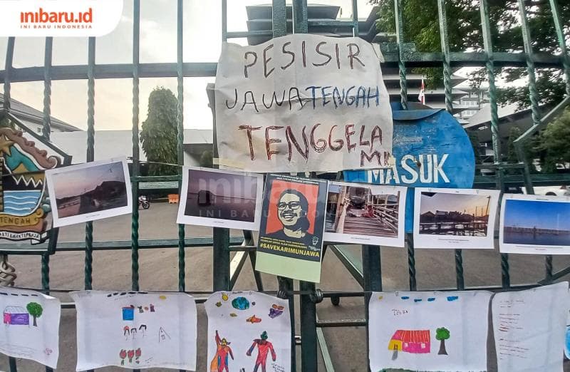 Tulisan 'Pesisir Jawa Tengah tenggelam' yang ditempel di pintu gerbang gedung gubernuran. (Inibaru.id/ Fitroh Nurikhsan)