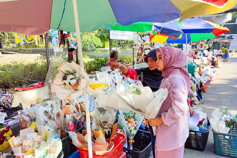 Seorang pembeli tengah memilih buket bunga yang akan diberikannya untuk sang kekasih tersayang yang sedang diwisuda.