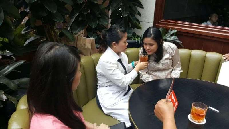 Reka ulang kejadian saat Wayan Mirna Salihin, yang diperankan pramusaji (tengah), sedang bersama dengan kedua sahabatnya, Hani (kiri) dan Jessica (kanan) di Kafe Olivier, Jakarta. (JPNN)