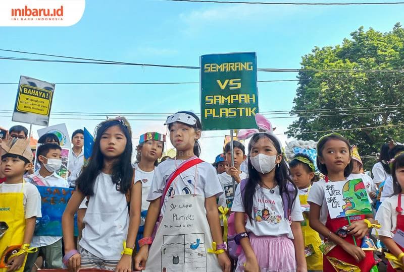 Anak-anak membentangkan poster bertuliskan "Semarang Vs Sampah Plastik". (Inibaru.id/ Fitroh Nurikhsan)