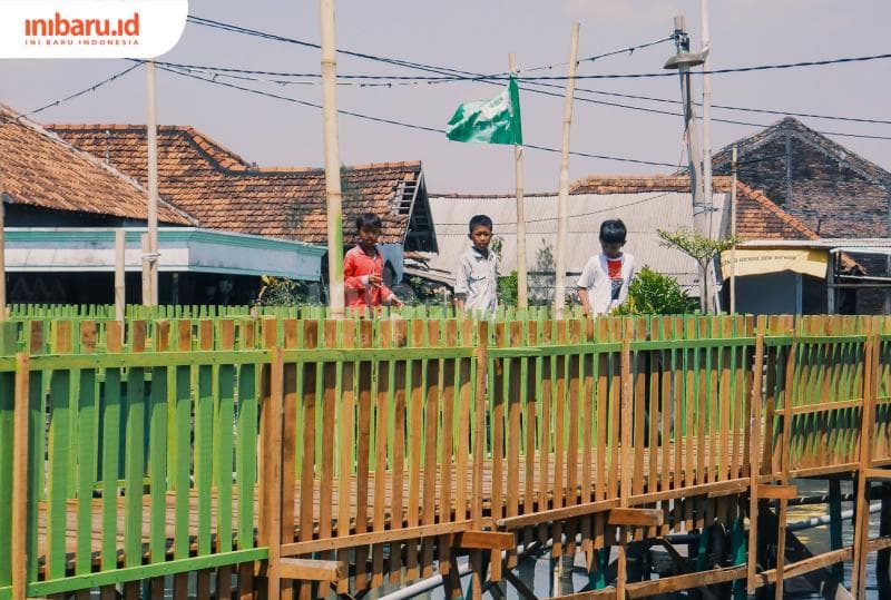 Wahyu dan anak-anak&nbsp;Dukuh Timbulsloko, Desa Timbulsloko, Kecamatan Sayung, Kabupaten Demak, berlari menuju madin apung nahdlatul ulama, Jumat (15/9/2023). (Inibaru.id/ Ayu Sasmita)
