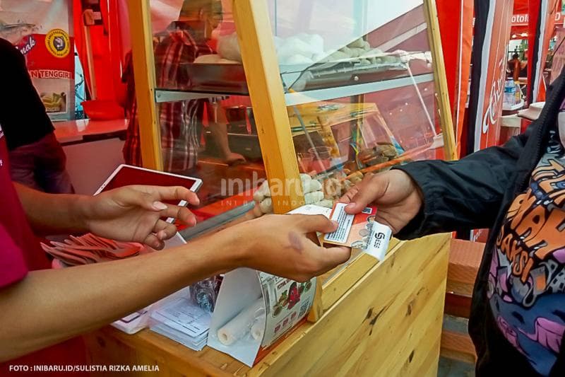 Transaksi antara penjual dan pembeli di Pasar Sentiling menggunakan kartu yang sediakan panitia.